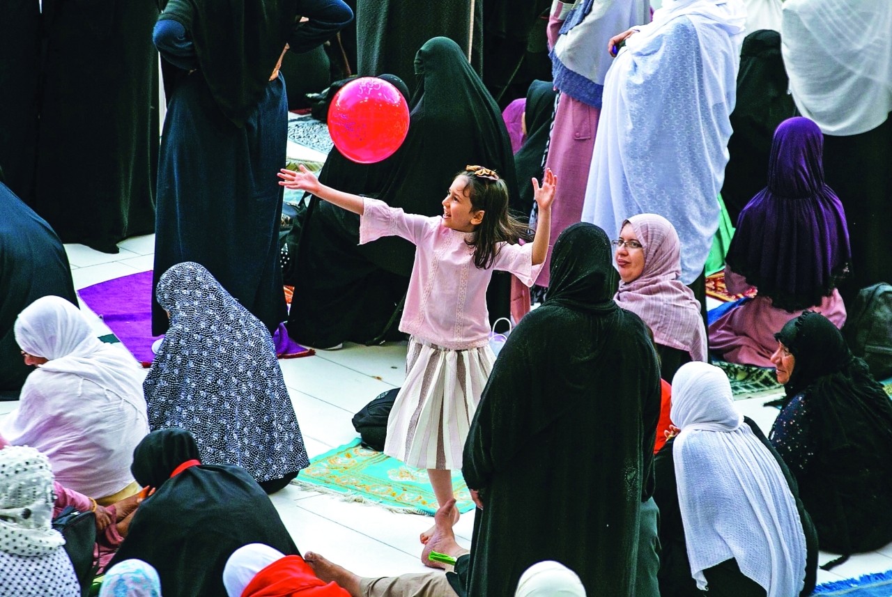 "أطفال مع عائلاتهم في باحة المسجد الحرام بمكة المكرمة | أ.ف.ب"