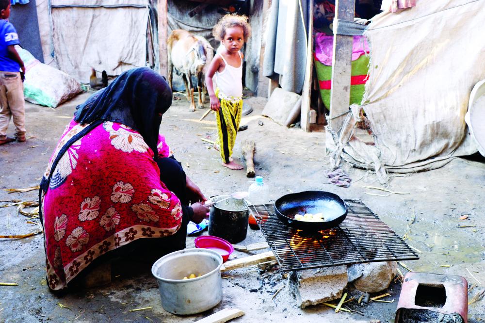 "A woman cooks at a makeshift camp for internally displaced people (IDPs) in Aden, Yemen March 15, 2022. Picture taken March 15, 2022. REUTERS/Fawaz Salman"