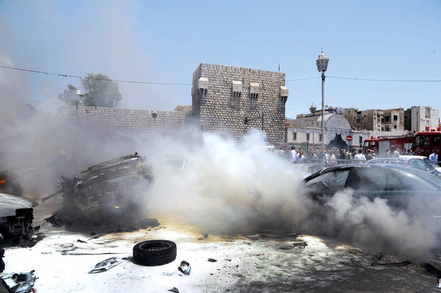 الصورة : الدخان يتصاعد من إحدى المركبات إثر التفجير في القصر العدلي