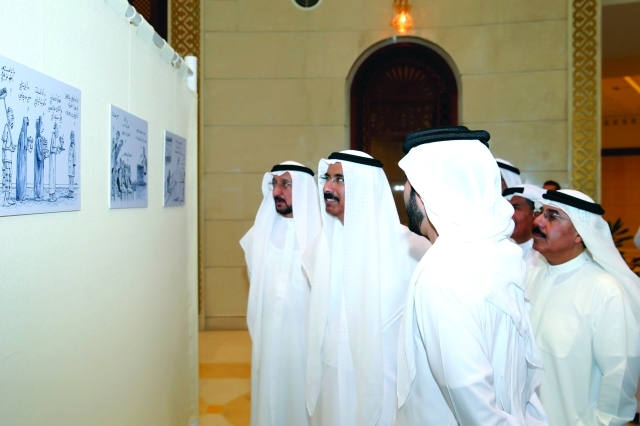 الصورة : المر والسويدي والهاملي يتابعون رسوماً في معرض الكاريكاتير 		تصوير ــ خالد نوفل