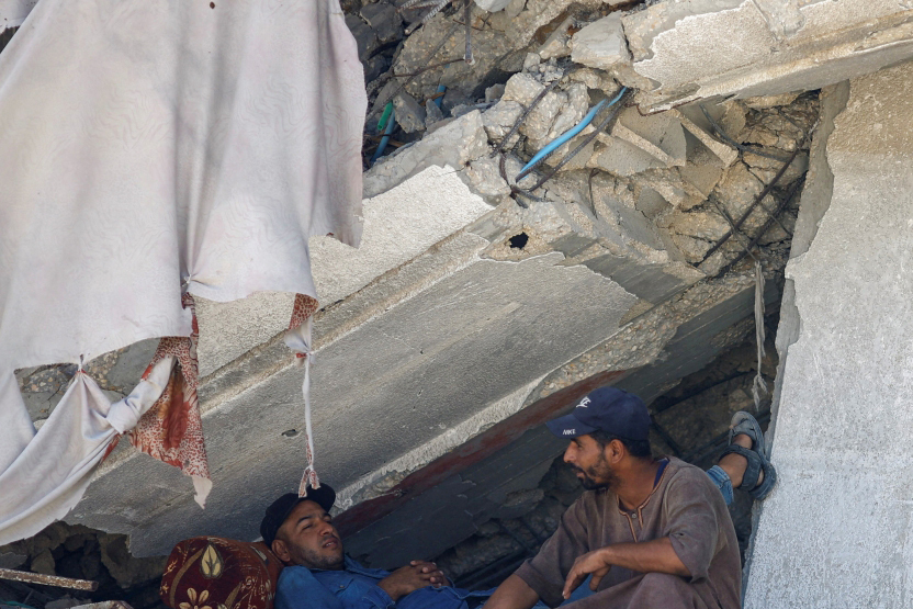 الصورة : خان يونس.. فلسطينيان يحتميان من القصف بالدمار الناجم عنه | رويترز